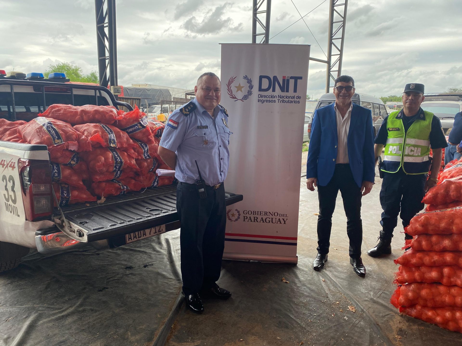 Personas posando junto con las donaciones de cebollas.