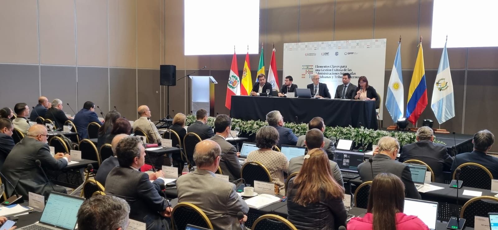 El evento tuvo lugar en el Paseo La Galería y tuvo como objetivo de analizar aspectos estratégicos, tácticos y operativos que permiten fortalecer las administraciones que tienen integradas las funciones de Aduanas y Tributos Internos. El director de la DNIT Óscar Orué, dio gracias a los que participaron del encuentro y en especial al Fondo Monetario Internacional por su permanente apoyo y dijo: “Queremos aplicar las mejores prácticas de la mano de expertos de distintos países que tienen experiencia en la fusión de Aduanas e Impuestos Internos, no solo para aumentar la recaudación, sino brindar servicios de calidad”. Participaron del encuentro internacional también el gerente general de aduanas Juan Olmedo, gerente general de impuestos internos Ever Otazú y el gerente Braulio Ferreira, además de expertos internacionales del FMI, BID, CIAT y de varios países.